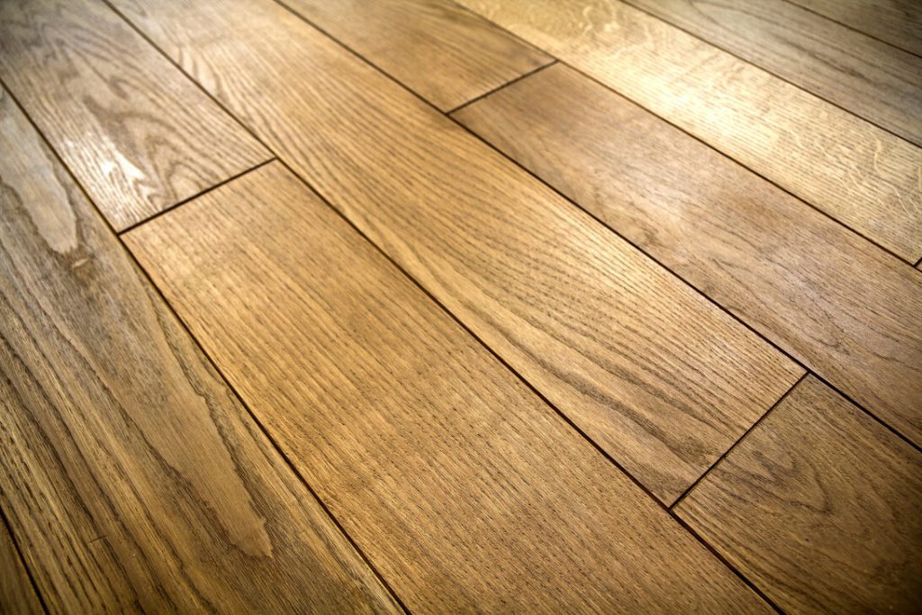 Close-up of a hardwood floor with warm-toned planks and visible grain seams.